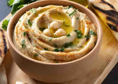 Hummus casero de garbanzos en cuenco de madera adornado con perejil receta de soy50plus