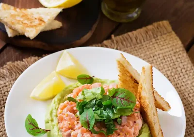 Plato de tartar de salmón con mousse de aguacate con tostadas. Receta soy50plus. Recetas con aguacates